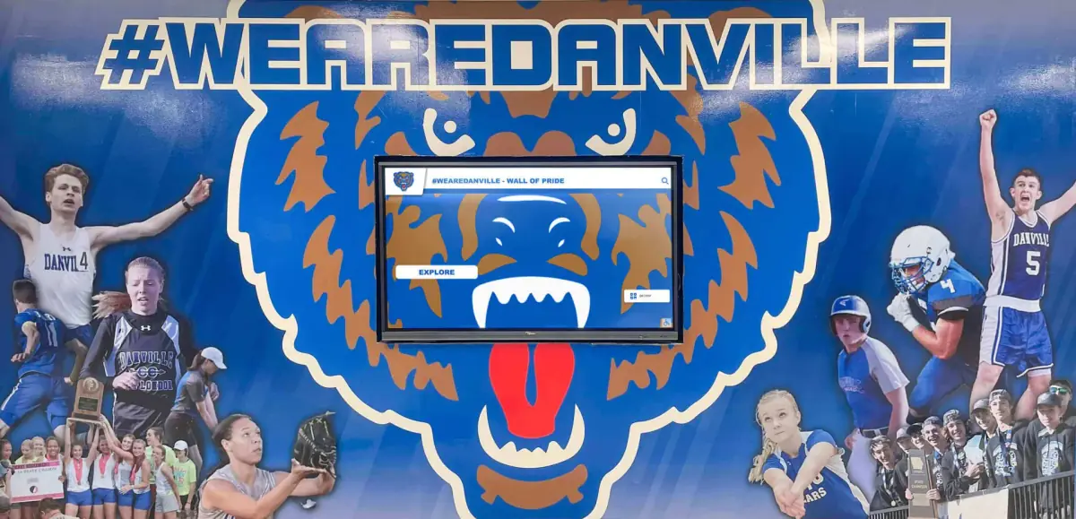A touchscreen hall of fame set into a #WeAreDanville mural of student-athletes